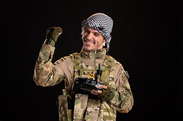 Веселый палестинский солдат с помощью пульта дистанционного управления на черной стене