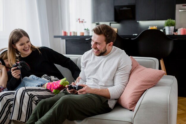 Cheerful parents playing video games near girl