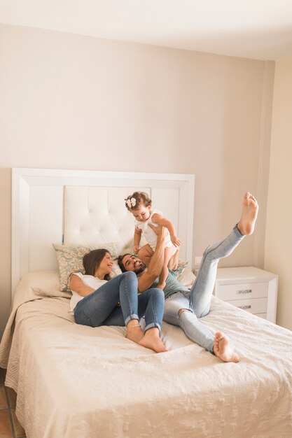 Cheerful parents playing with daughter