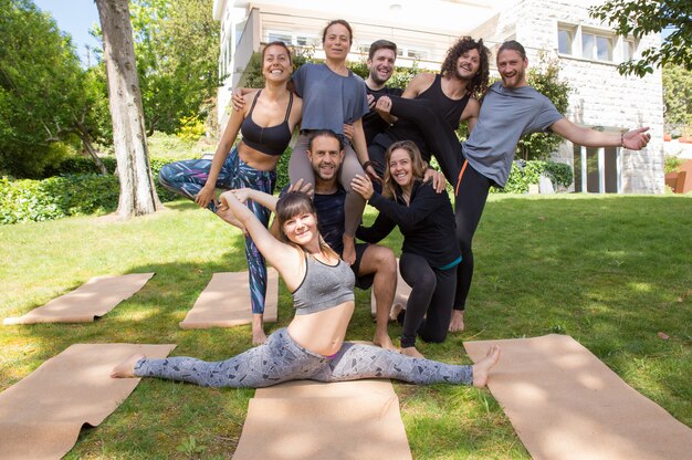 Cheerful people from yoga team posing outdoors