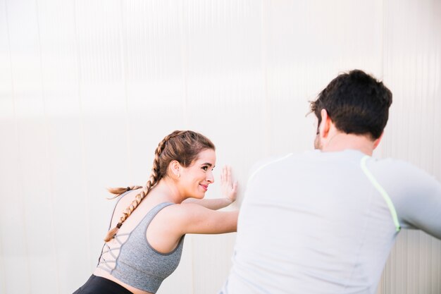 Cheerful people training near wall