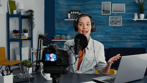 Free photo cheerful popular internet podcast show host ending live stream while sending air kisses to public. social media popular infulencer saying goodbye to audience while sitting at home studio desk.