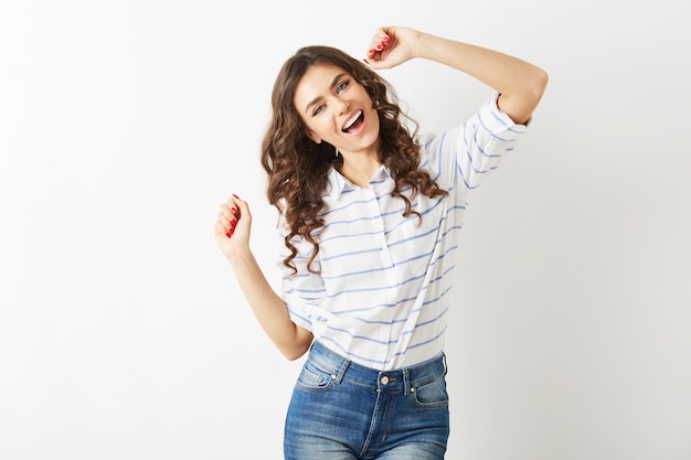 Allegro ritratto di giovane donna graziosa che balla felice, espressione del viso sorridente, capelli lunghi, stato d'animo positivo, emotivo, vestito stile hipster, tendenza moda estiva, jeans e camicia a righe, isolato