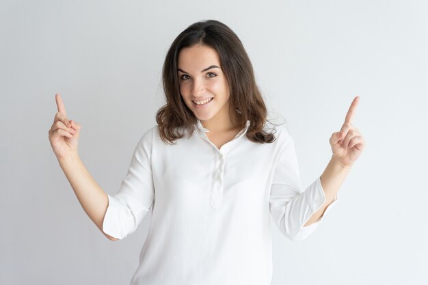 Cheerful positive girl presenting information above. 