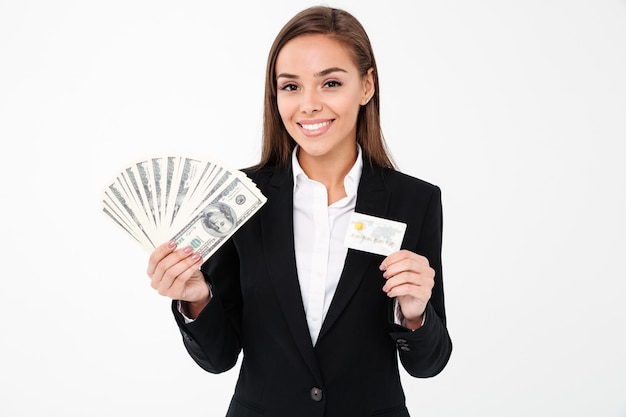 Cheerful pretty businesswoman holding money and credit card
