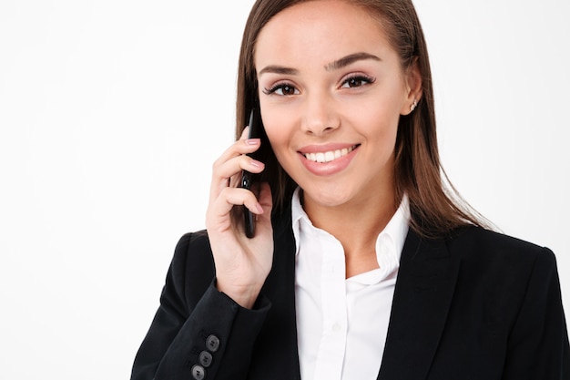 Cheerful pretty businesswoman talking by phone