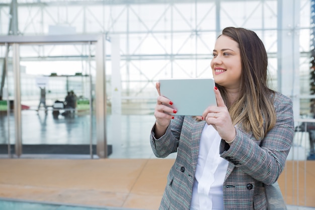 Cheerful professional using digital gadget for shooting