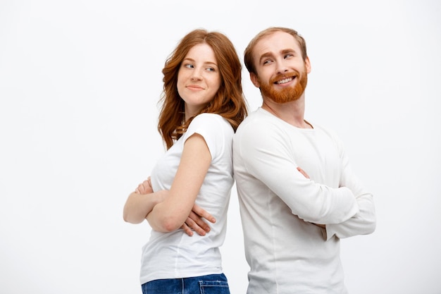 Cheerful redhead girl with boy dressed in white shirt standing