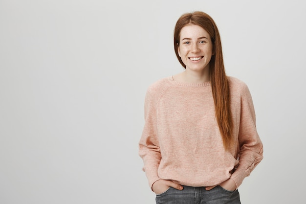 Cheerful redhead girl with freckles smiling