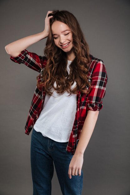 Cheerful relaxed young woman standing and laughing