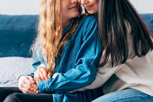 Cheerful same-sex couple hugging at home