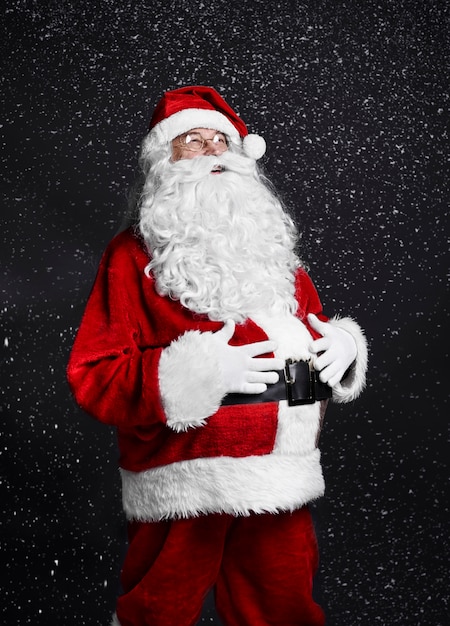 Free photo cheerful santa claus touching his belly