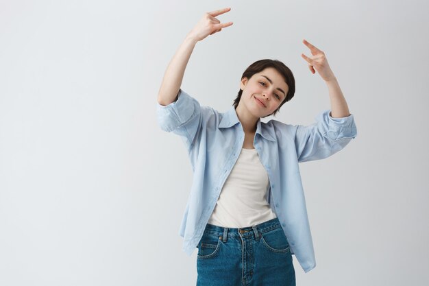 Cheerful sassy girl tomboy making rock-on gesture, enjoying music festival or party