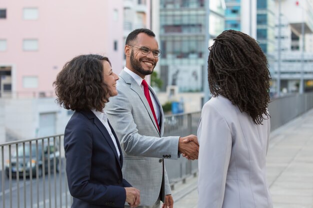 Cheerful satisfied partners finishing up meeting