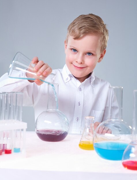 Cheerful schoolboy in chemistry class