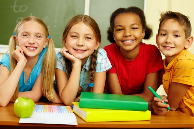 Cheerful schoolchildren with blackboard background