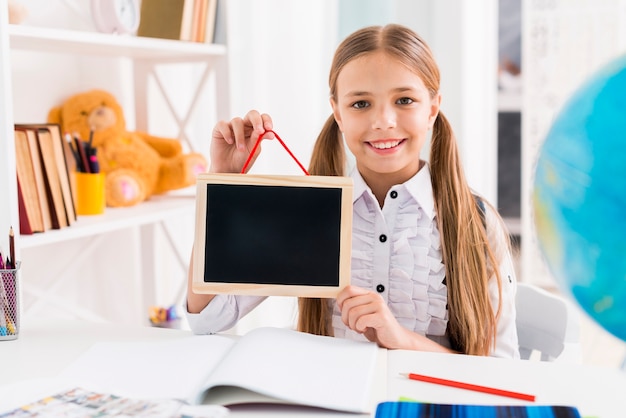 Cheerful schoolgirl in uniform studying at class