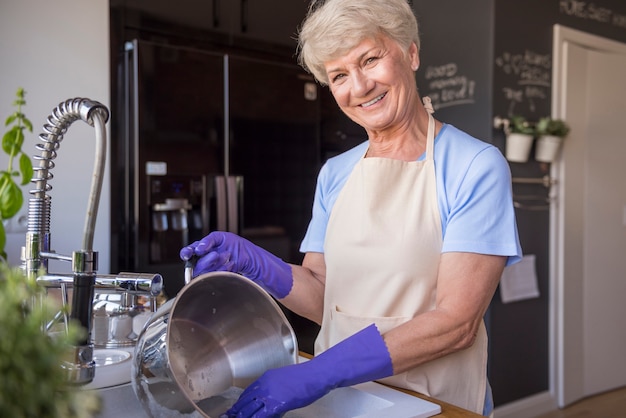 Foto gratuita casalinga senior allegra in cucina