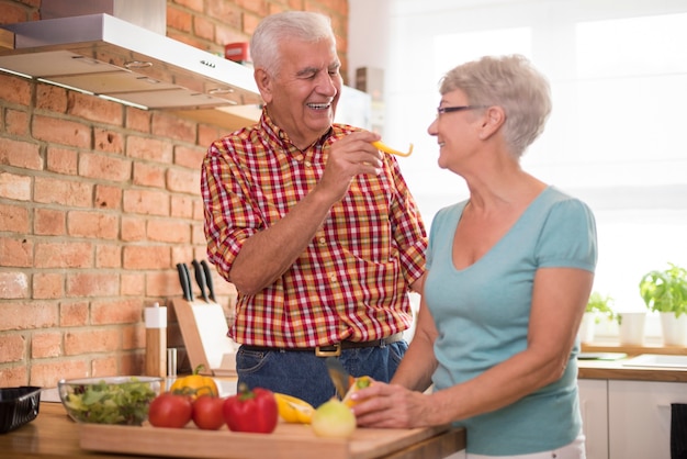 Foto gratuita allegro matrimonio senior che prepara un pasto sano