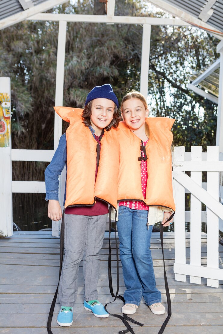 Free Photo cheerful siblings prepared for the boat ride