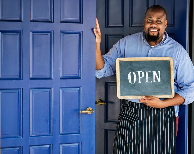 A cheerful small business owner with open sign