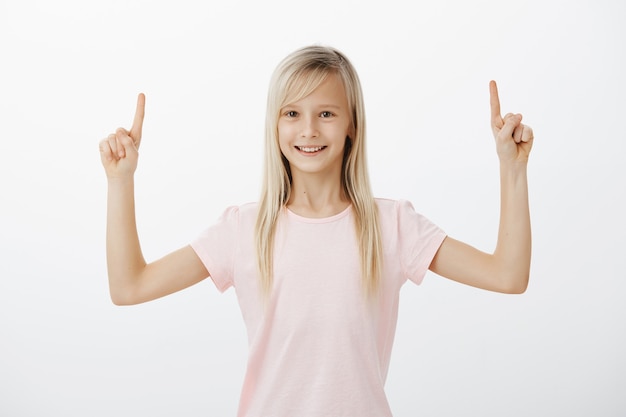 Foto gratuita allegro bambino sorridente che punta le dita verso l'alto