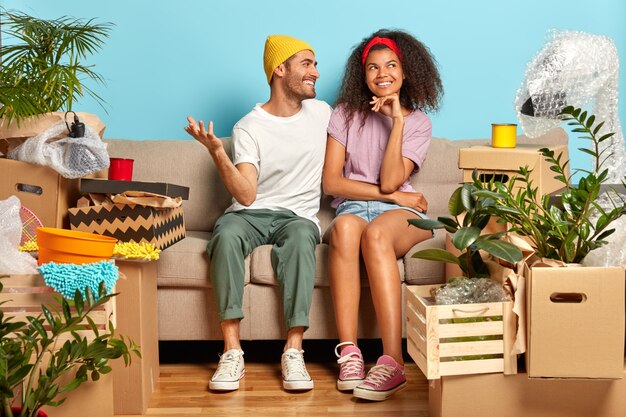 Веселая улыбающаяся семейная пара мечтает о хорошем будущем в своей новой квартире