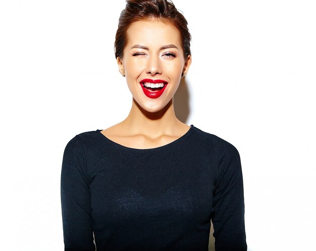 cheerful smiling winking fashion woman going crazy in casual black clothes with red lips on white wall