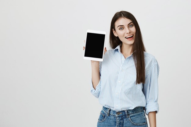 Cheerful smiling woman showing digital tablet screen
