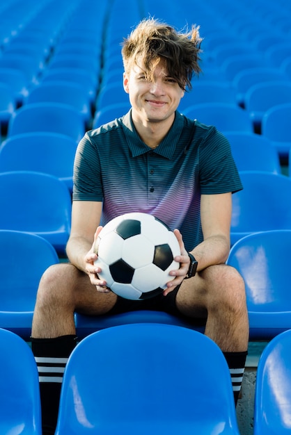 Free photo cheerful soccer player on stadium