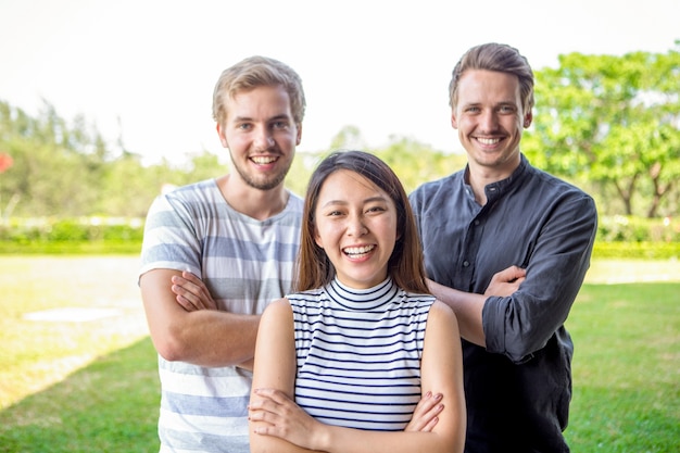 Cheerful student friends standing folding arms