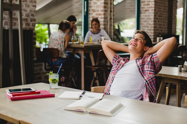 Free photo cheerful student relaxing at table