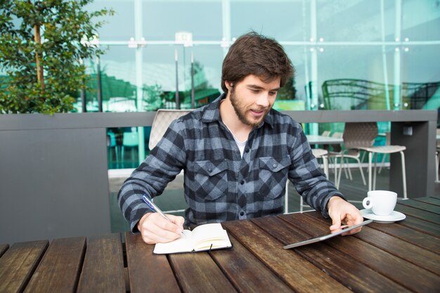 Cheerful student taking notes for essay