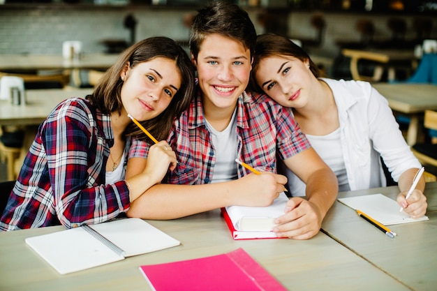 Foto gratuita allegri studenti che presentano al tavolo