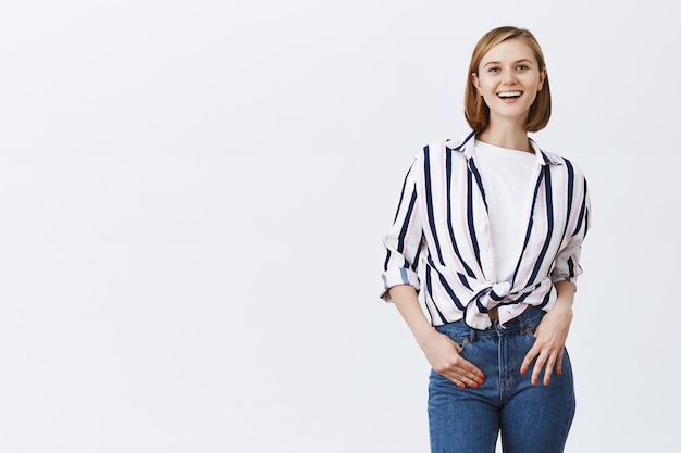 Cheerful stylish blond girl looking amused and happy