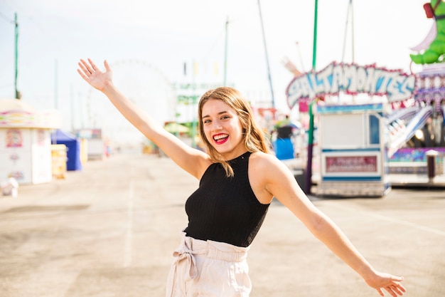 Cheerful stylish young woman at fairground