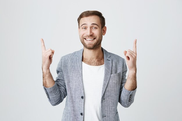 Cheerful successful businessman pointing up