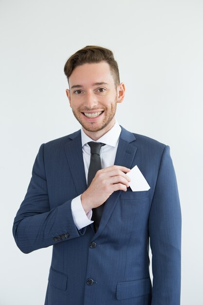 Cheerful successful handsome businessman with card