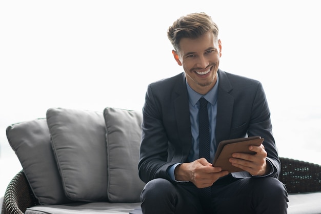 Cheerful Successful Young Man Using Tablet Computer