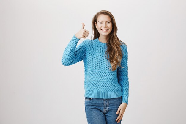 Cheerful supportive woman thumb-up in approval