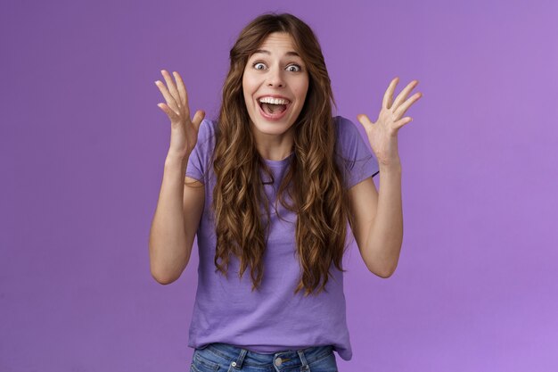 Cheerful surprised happy girl receive unbelievable super prize winning triumphing smiling joyfully shake hands excitement joy celebrating perfect news grinning happily victory purple background