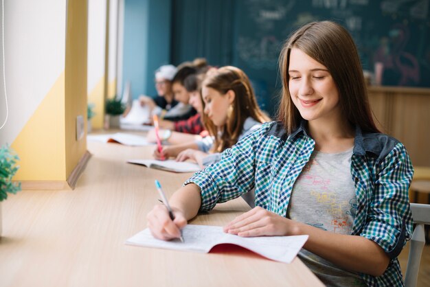 Cheerful teen preparing homework