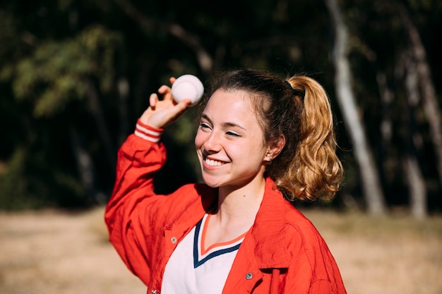 Cheerful teen student throwing baseball