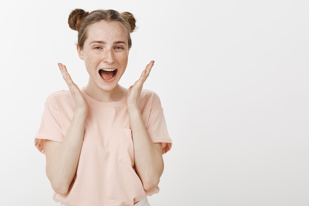 Cheerful teenage girl posing against the white wall