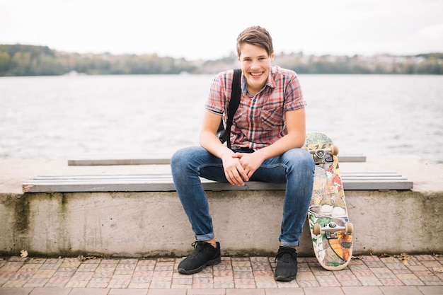 Cheerful teenager on bench lookin at camera