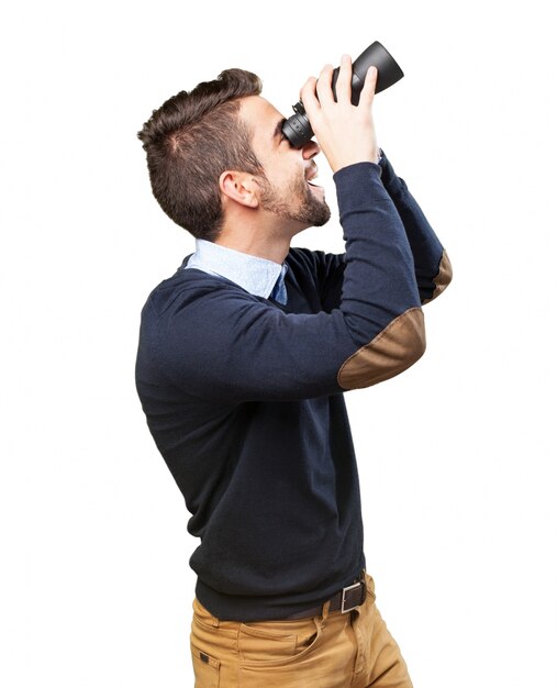 Cheerful teenager having a good time with his binoculars