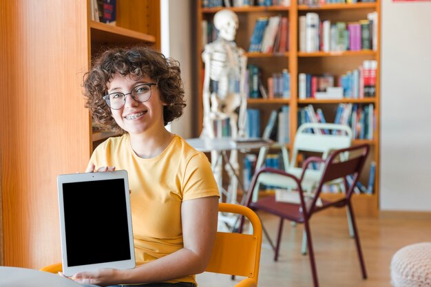 Cheerful teenager showing modern tablet