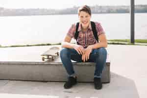 Free photo cheerful teenager sitting on border