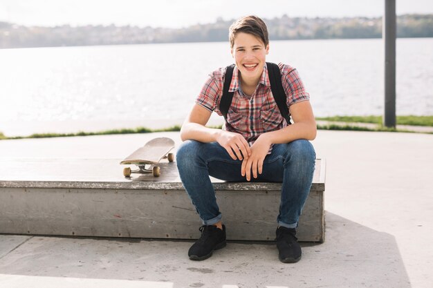 Cheerful teenager sitting on border