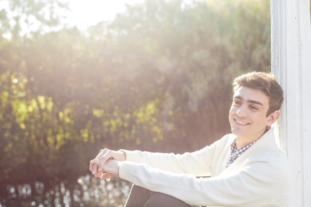 Cheerful teenager sitting outdoors